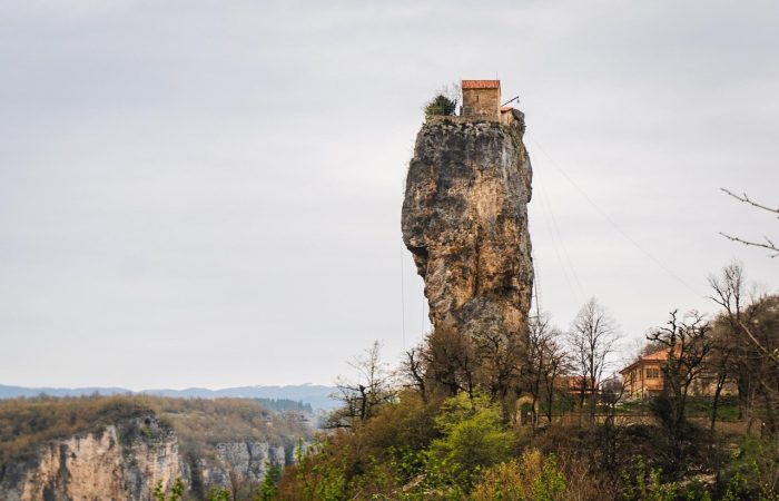 Scenic view of the Katskhi Pillar near Chiatura, Georgia, featuring the ancient monolithic limestone column with a small church perched on top, symbolizing Georgian Orthodox Christian heritage