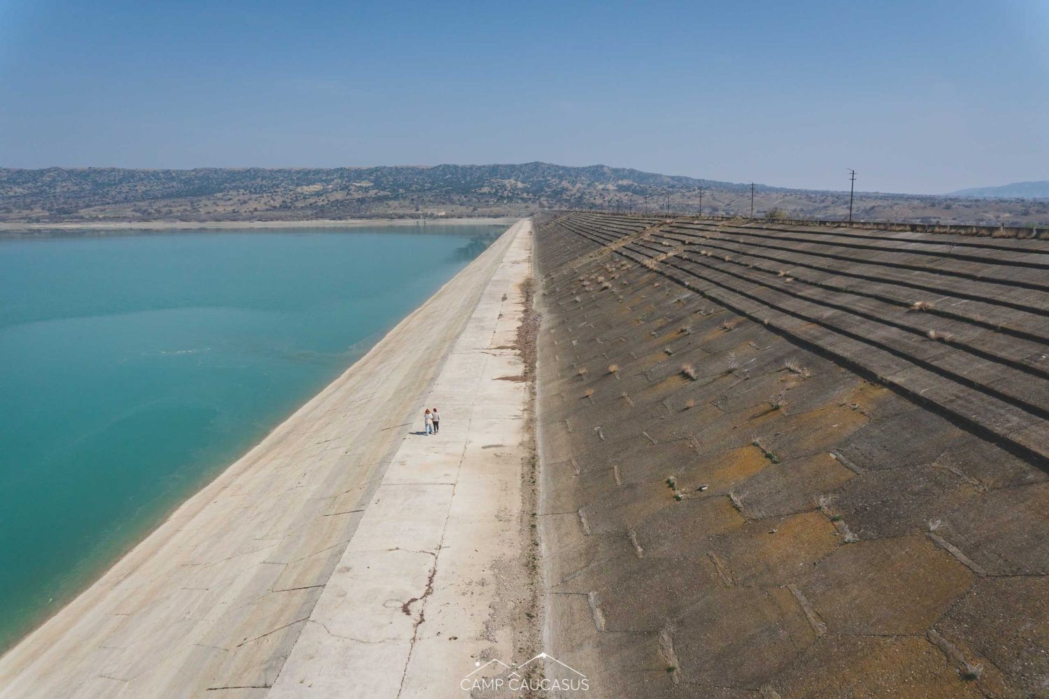 Abandoned dam tower reflected in green water of Dali Mountain Reservoir, Vashlovani, Georgia