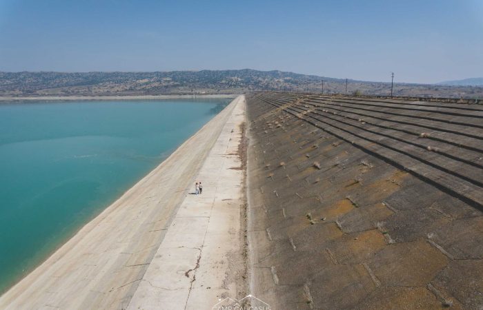 Abandoned dam tower reflected in green water of Dali Mountain Reservoir, Vashlovani, Georgia
