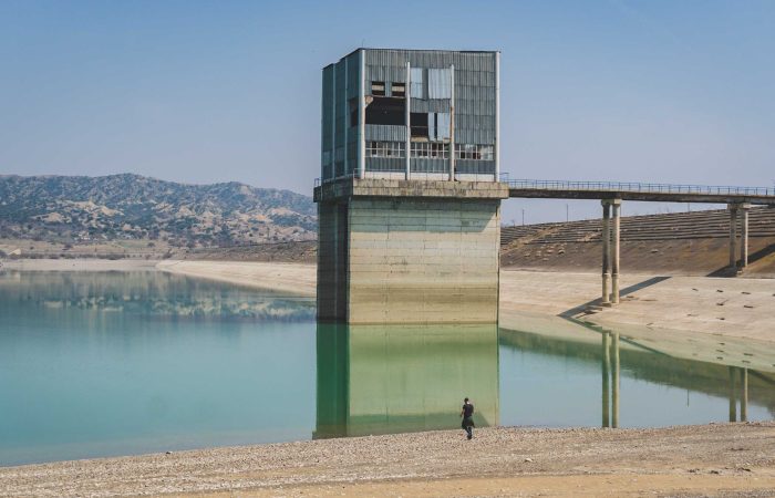 Person walking near Dali Mountain reservoir water control tower at Vashlovani reservoir, Georgia