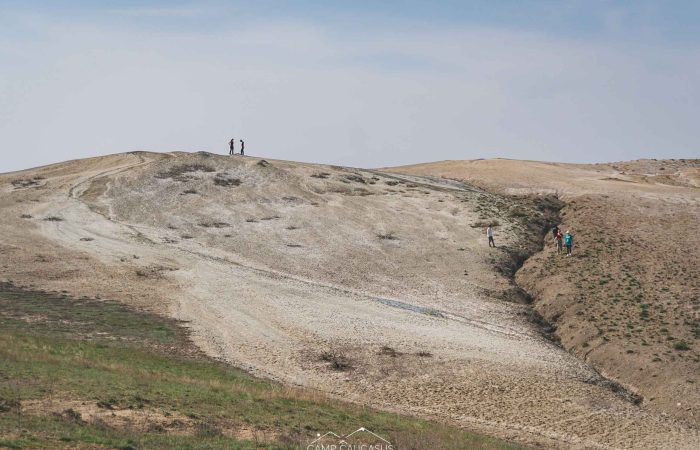 Hikers exploring Takhti-Tepha mud volcano hills in Vashlovani National Park, Georgia