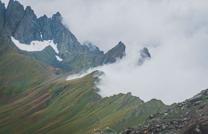 Cloud-covered Tobavarchkhili mountain peaks along hiking trail