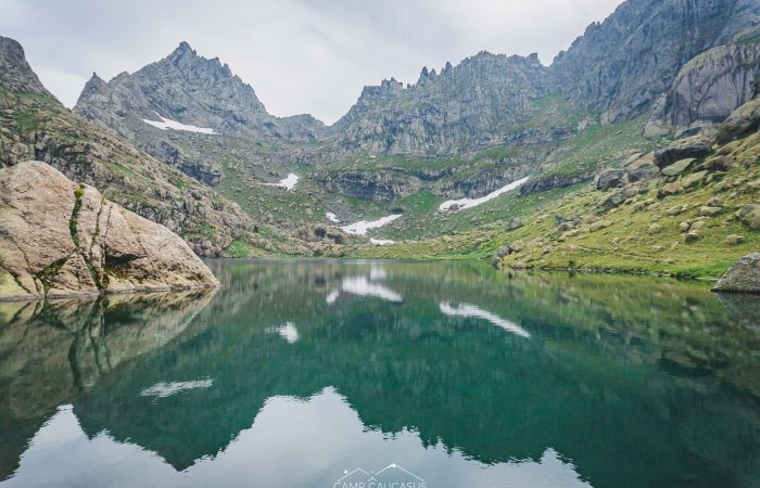 Mirror-like alpine lake along Tobavarchkhili trek in the Caucasus