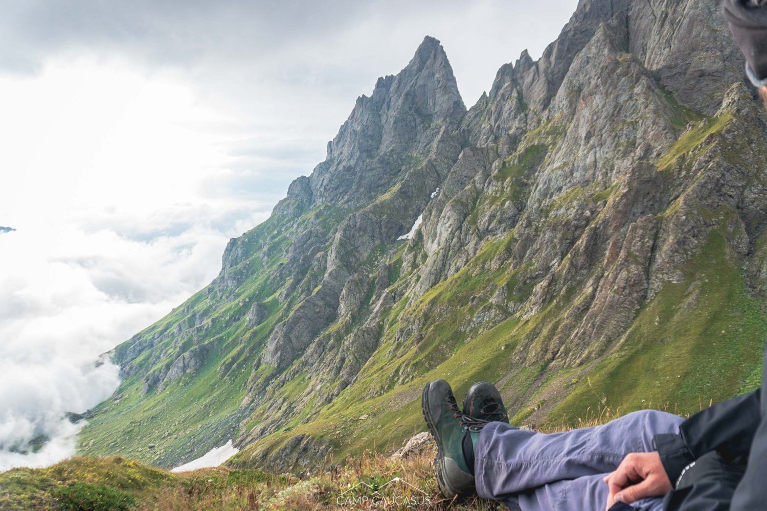 Tired hiker resting with view of Tobavarchkhili's dramatic ridgelines
