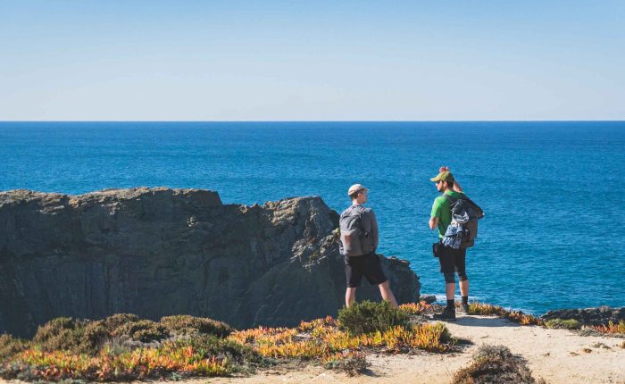 Hikers walking along the Fisherman’s Trail near Zambujeira do Mar, Portugal.