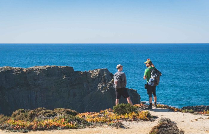 Hikers walking along the Fisherman’s Trail near Zambujeira do Mar, Portugal.