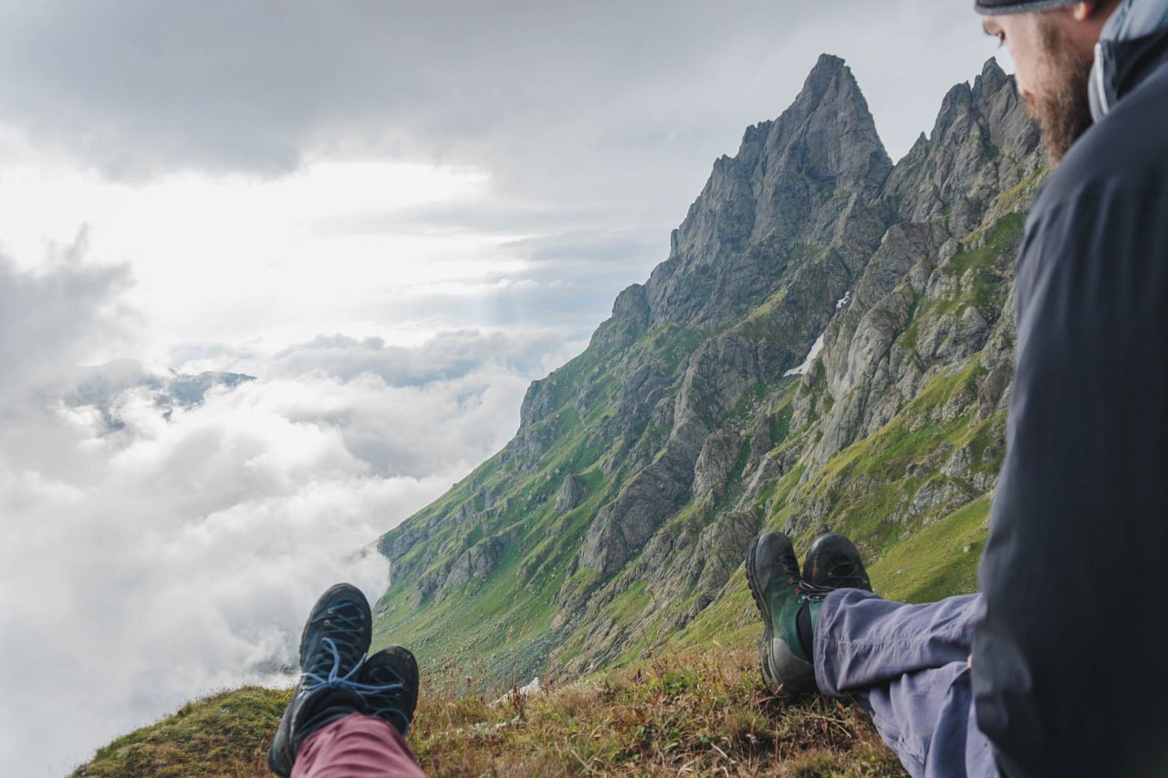 Travelers resting on a mountain ridge above the clouds during a Camp Caucasus trekking expedition.